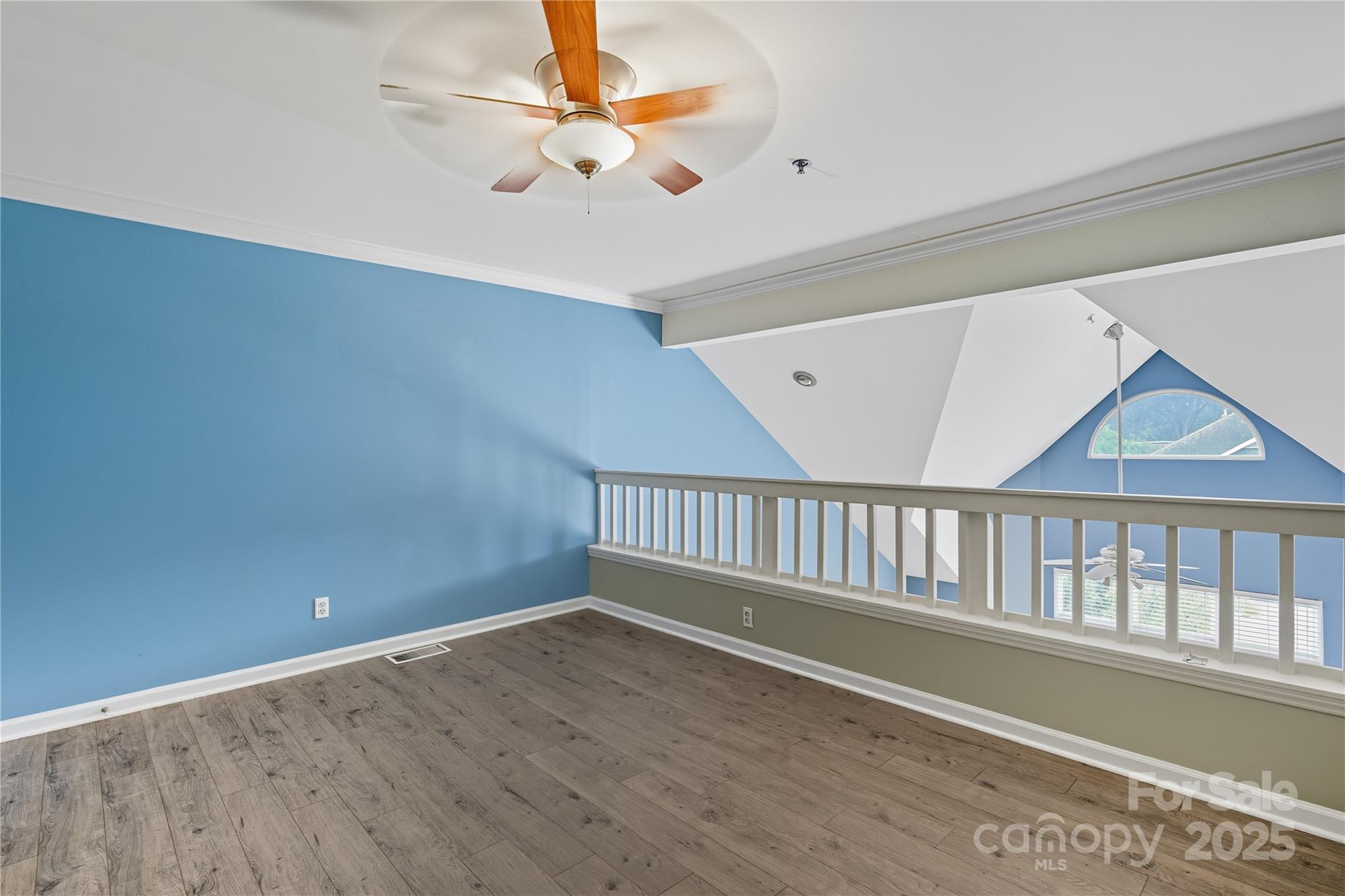 509 North Graham Street, Unit 3J Charlotte, NC 28202 - Photo 21 of 32 an empty room with wooden floor fan and windows