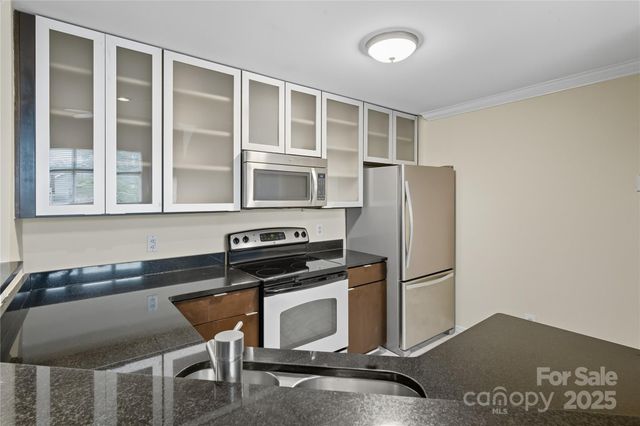 a kitchen with granite countertop a stove and a refrigerator