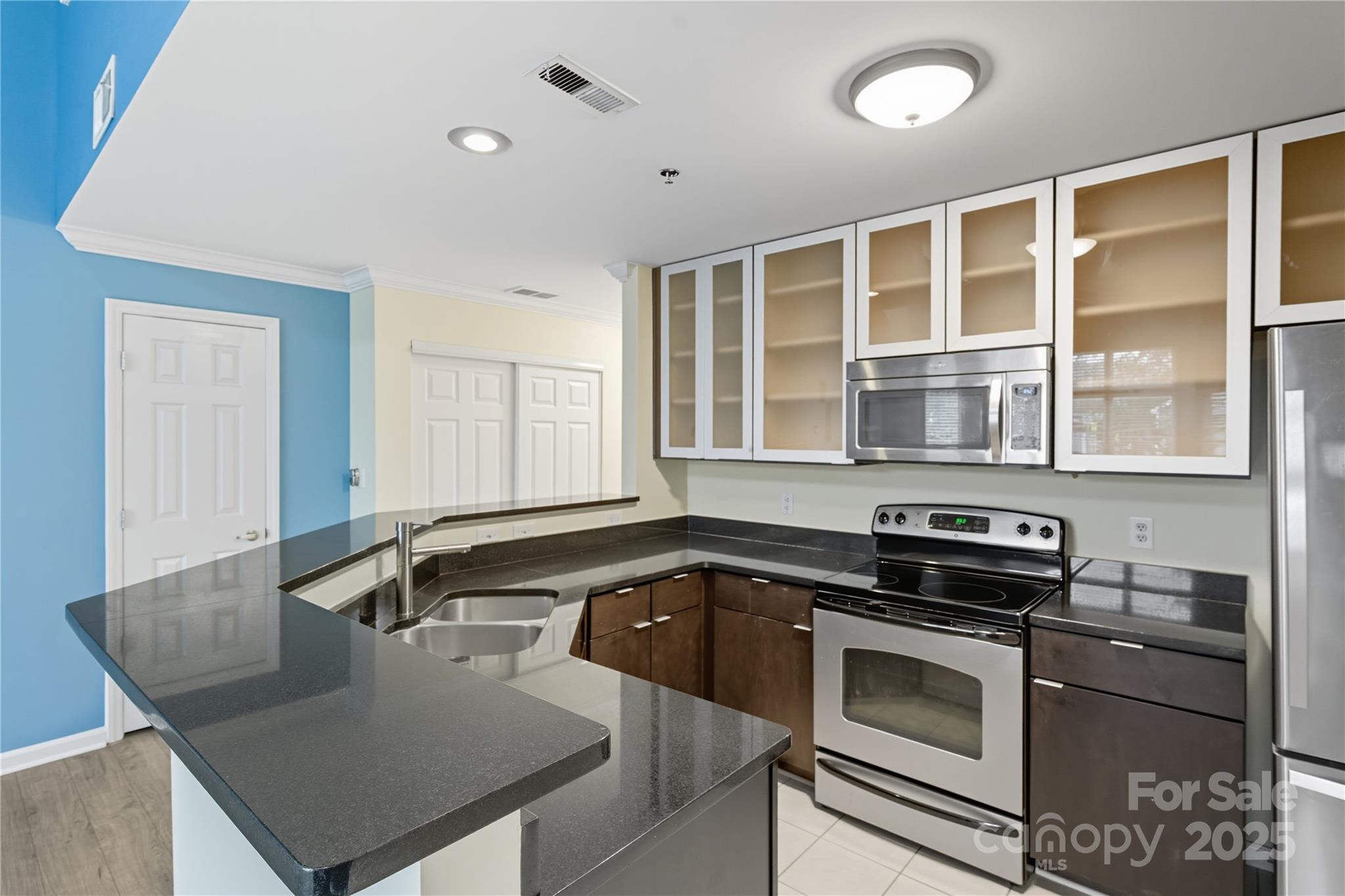 509 North Graham Street, Unit 3J Charlotte, NC 28202 - Photo 9 of 32 a kitchen that has a sink and a stove