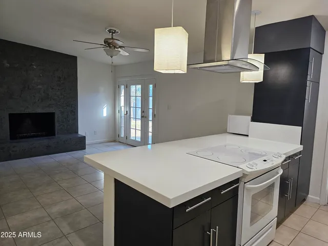 a living room with a fireplace furniture a ceiling fan and a rug
