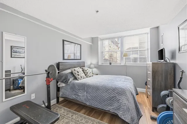 a bedroom with a bed and wooden floor