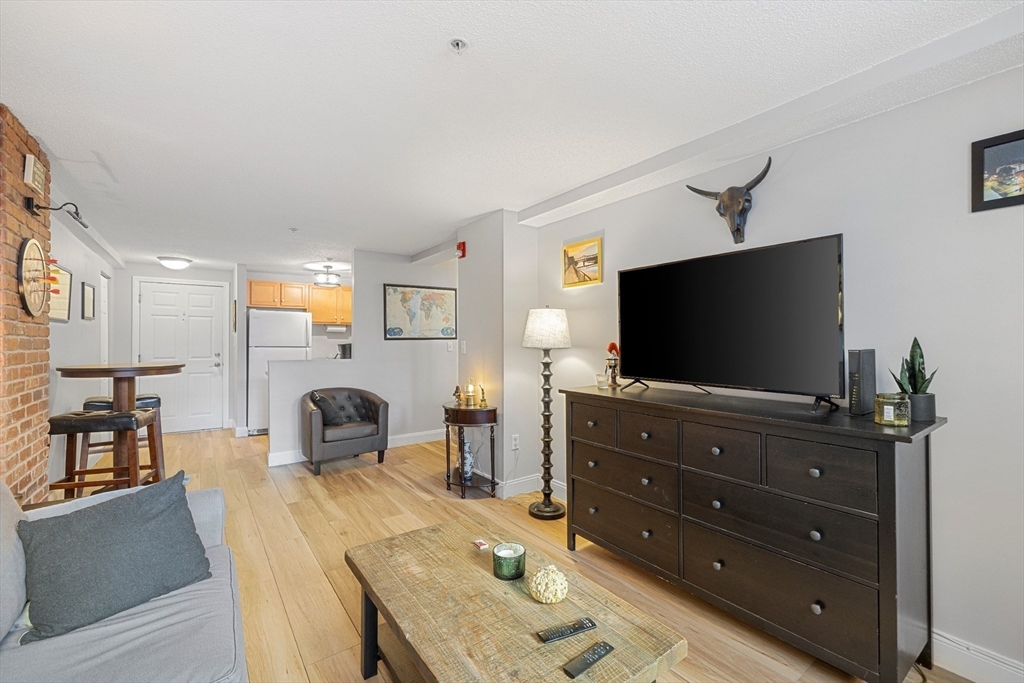 200 Market Street, Unit 4303 Lowell, MA 01852 - Photo 8 of 19 a living room with furniture and a flat screen tv