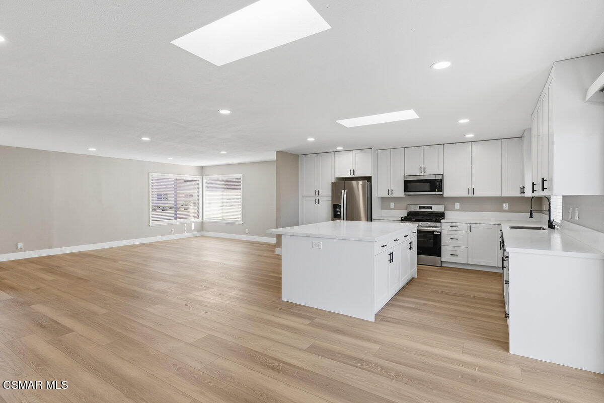 1069 Donner Avenue Simi Valley, CA 93065 - Photo 8 of 24 a large kitchen with stainless steel appliances granite countertop a large counter top and a stove top oven