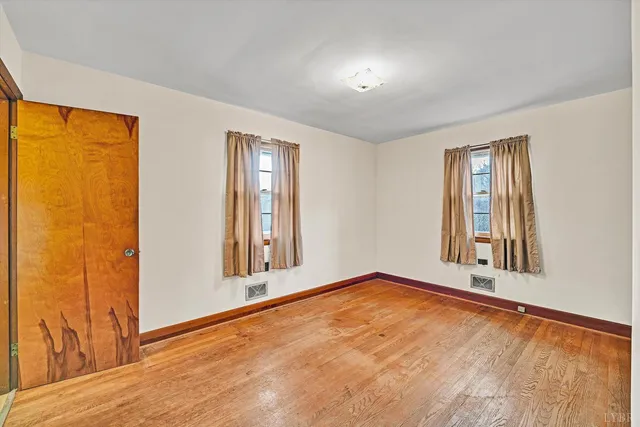 an empty room with windows and closet