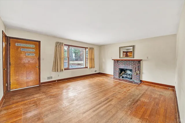 wooden floor fireplace and windows in an empty room