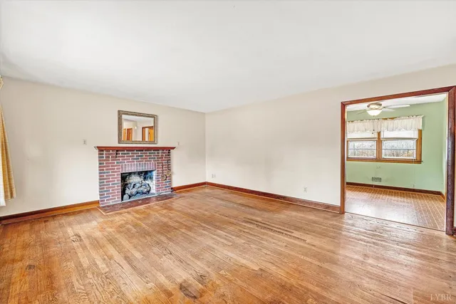 a view of an empty room with a fireplace and a window