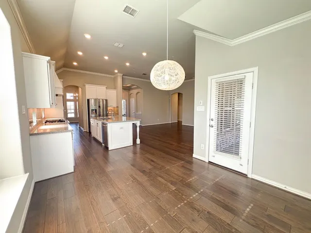 a large kitchen with stainless steel appliances granite countertop a lot of counter space and wooden floor