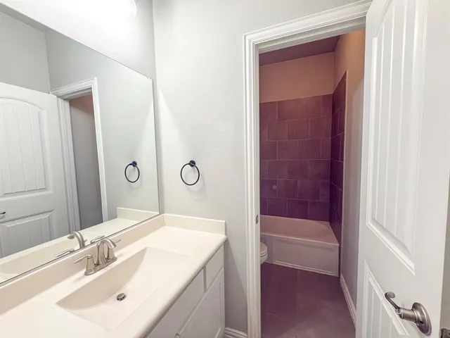 an empty room with windows and chandelier fan