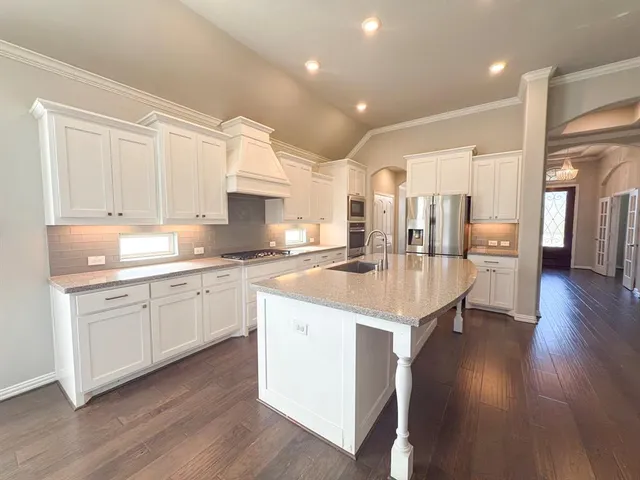 a kitchen with a sink cabinets and wooden floor