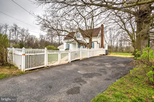 a view of a house with a yard and fence