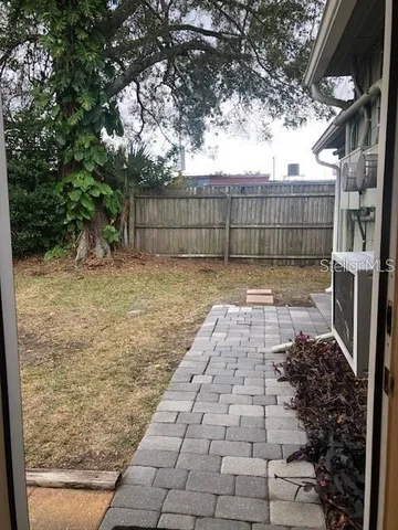 a view of a yard with wooden fence