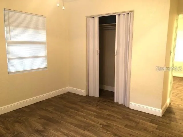 an empty room with wooden floor and a window