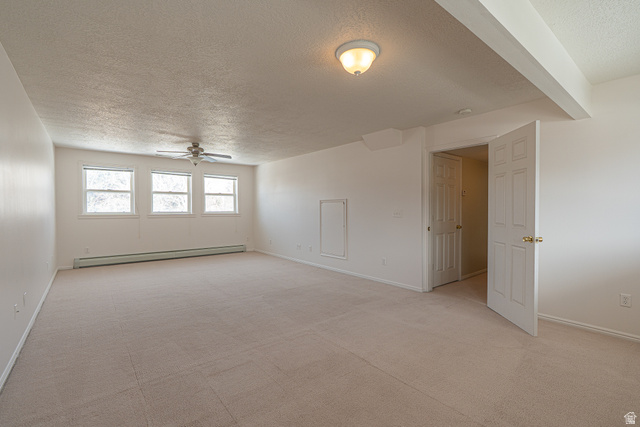 1045 Fox Farm Road Logan, UT 84321 - Photo 48 of 65 Unfurnished room with a textured ceiling, a baseboard heating unit, light carpet, and a ceiling fan