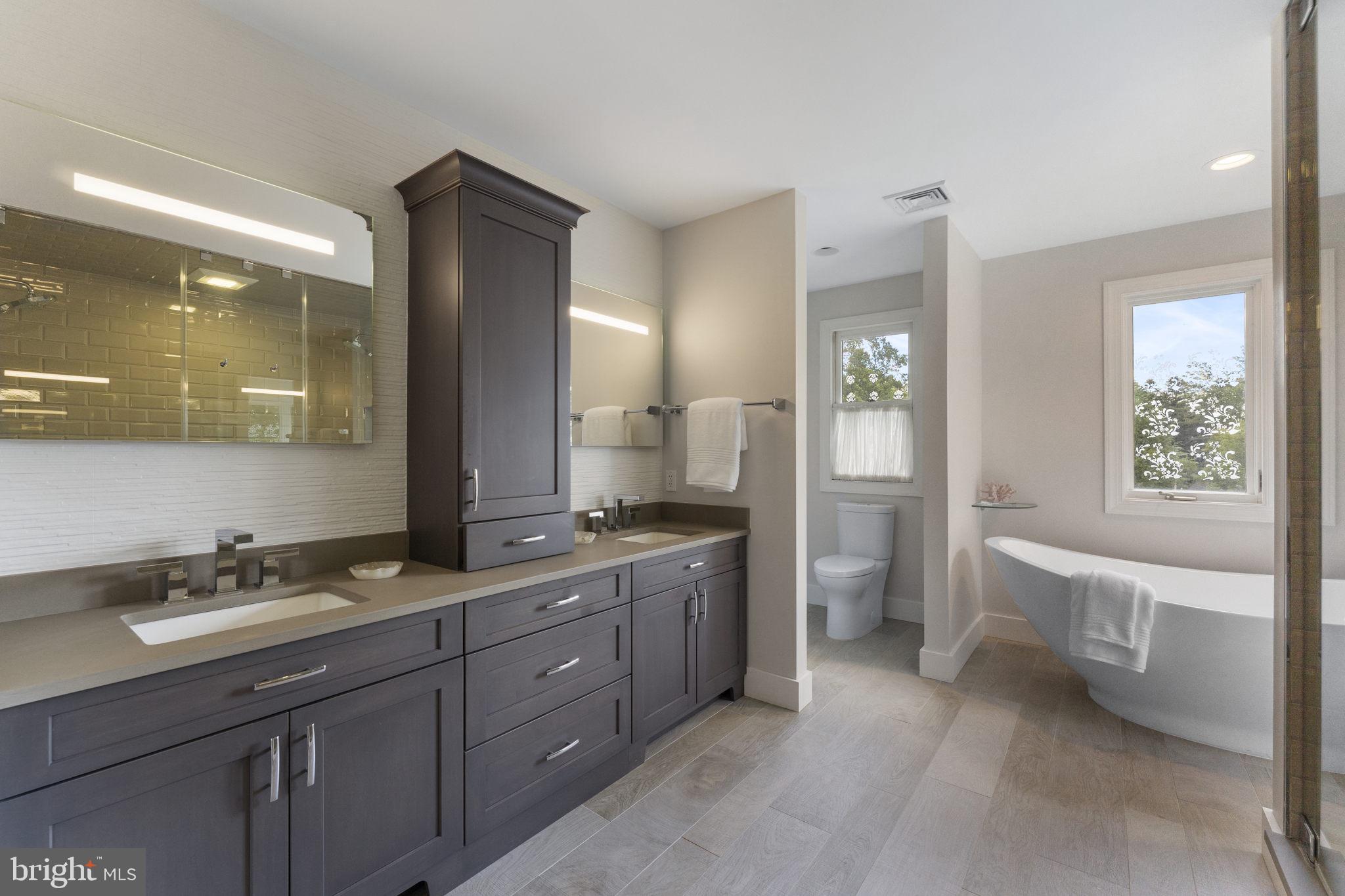 1122 King Of Prussia Road Wayne, PA 19087 - Photo 18 of 33 a spacious bathroom with a double vanity sink a large mirror and a bathtub