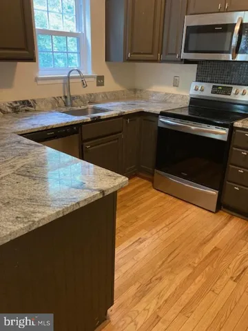a view of a room with wooden floor and fan