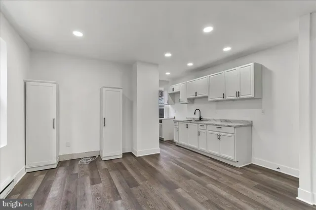 a open kitchen with kitchen island white cabinets and stainless steel appliances