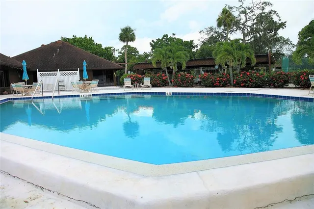 an aerial view of a house with swimming pool and outdoor seating