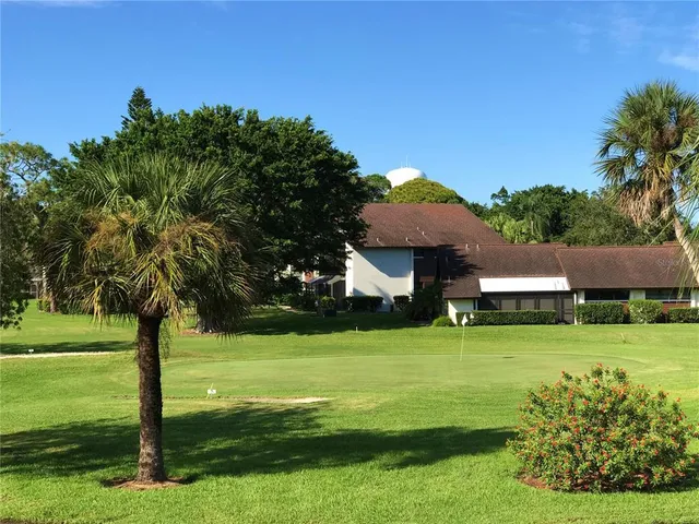 a view of a house with a big yard and large trees