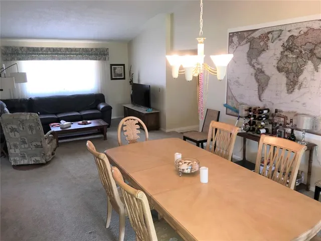 a dining room with furniture a chandelier and a flat screen tv