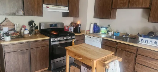 a kitchen with stainless steel appliances a stove a sink dishwasher and cabinets
