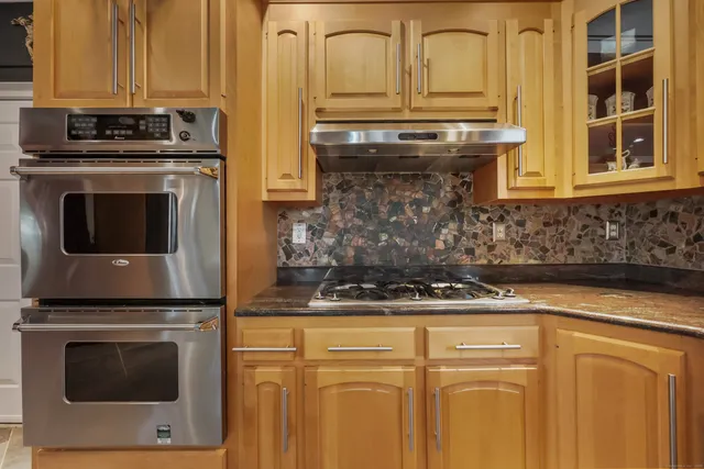 a kitchen with stainless steel appliances granite countertop a stove and a microwave