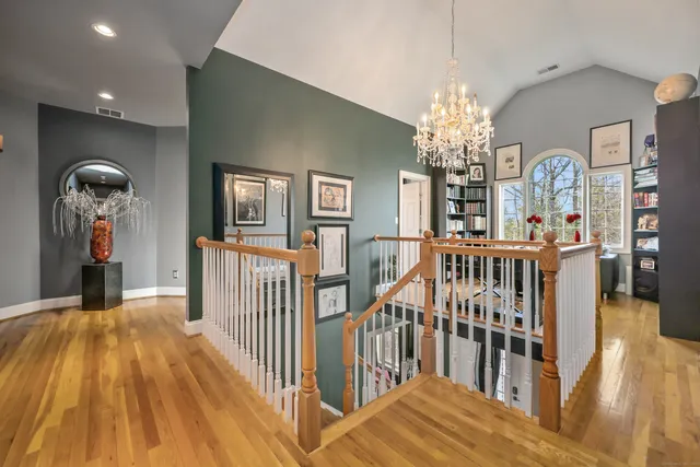 a view of a hallway with wooden floor and windows