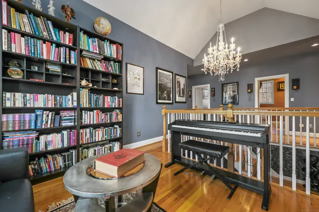 a living room with bookshelf a desk and a book shelf