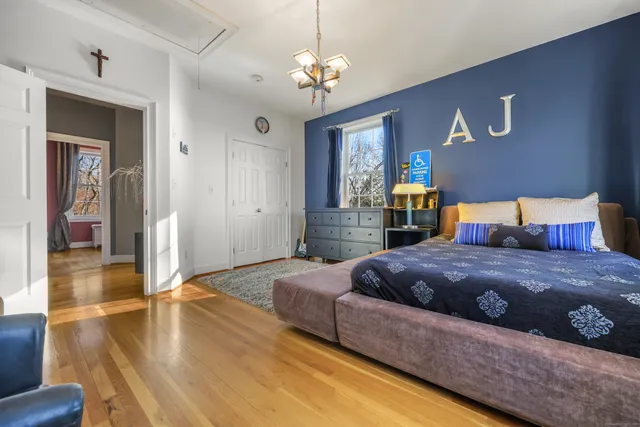 a bedroom with a large bed a chandelier and closet
