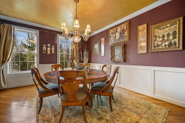 a dining room with furniture a chandelier and wooden floor