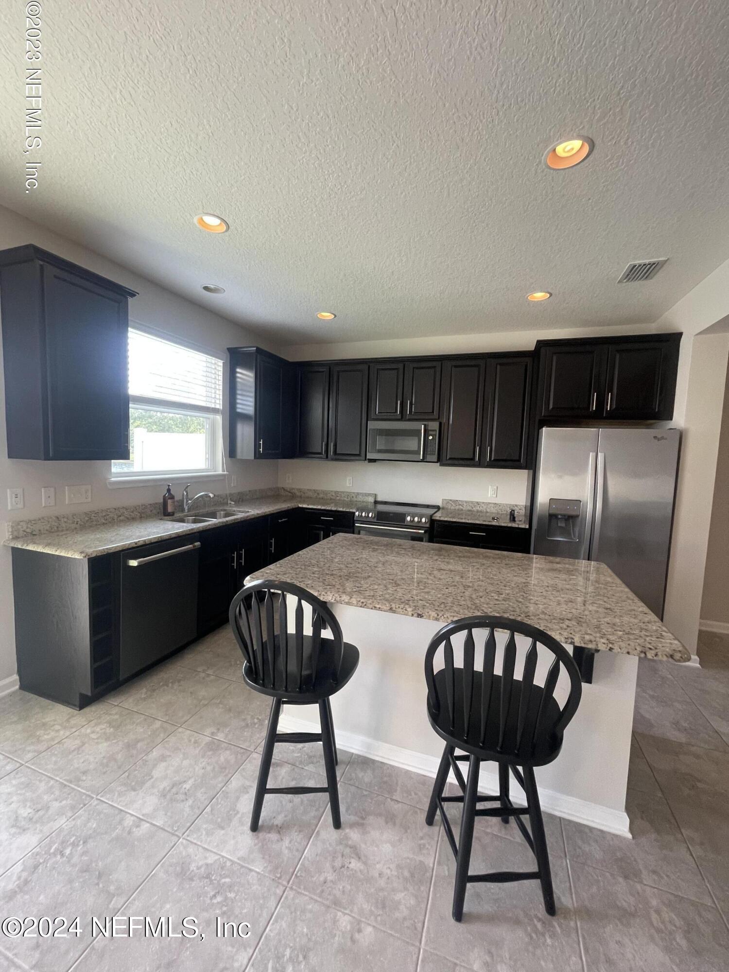 144 Nelson Lane St. Johns, FL 32259 - Photo 2 of 18 a kitchen with a chandelier a sink and cabinets