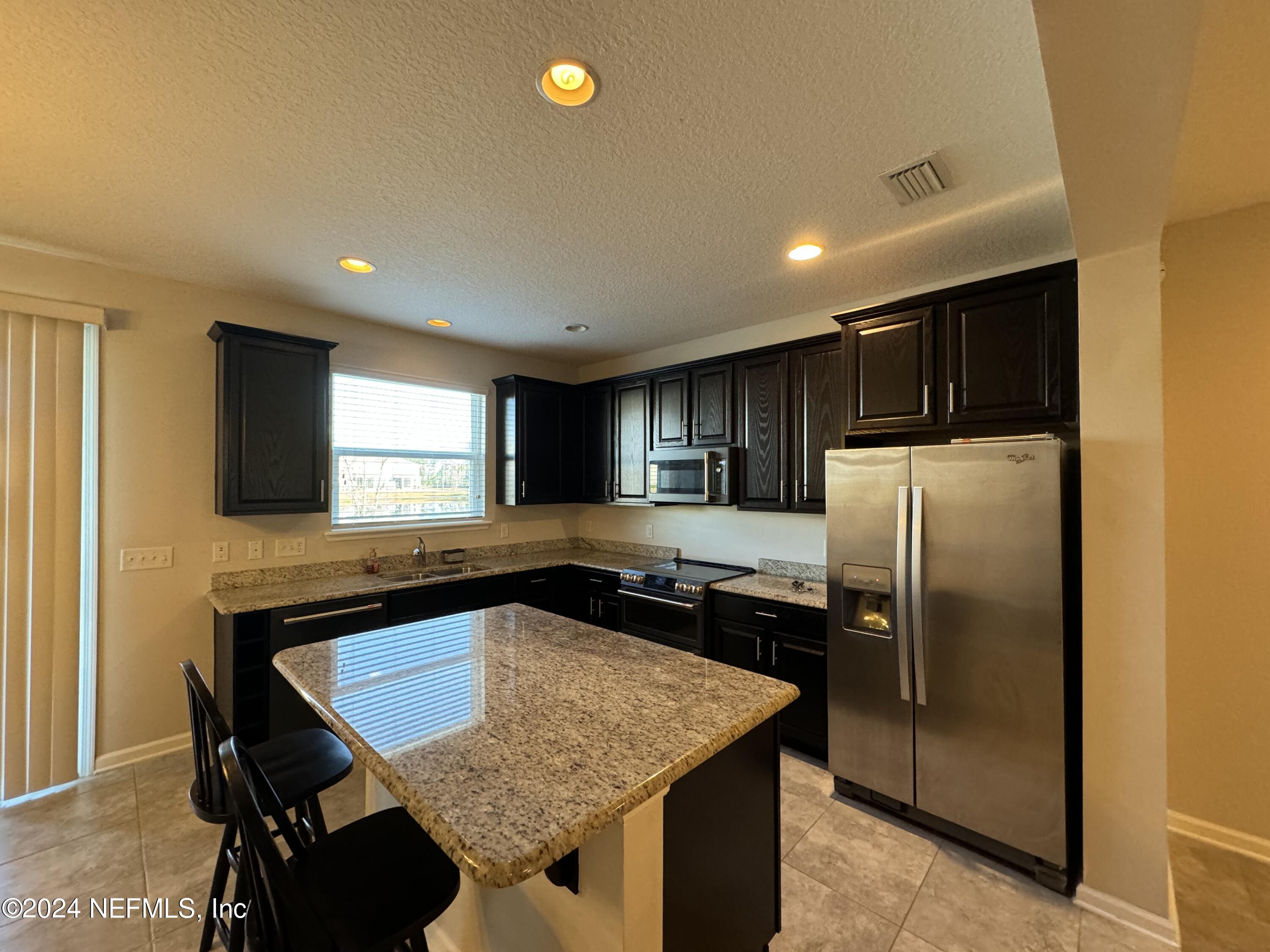 144 Nelson Lane St. Johns, FL 32259 - Photo 4 of 18 a kitchen with stainless steel appliances granite countertop refrigerator sink microwave and stove