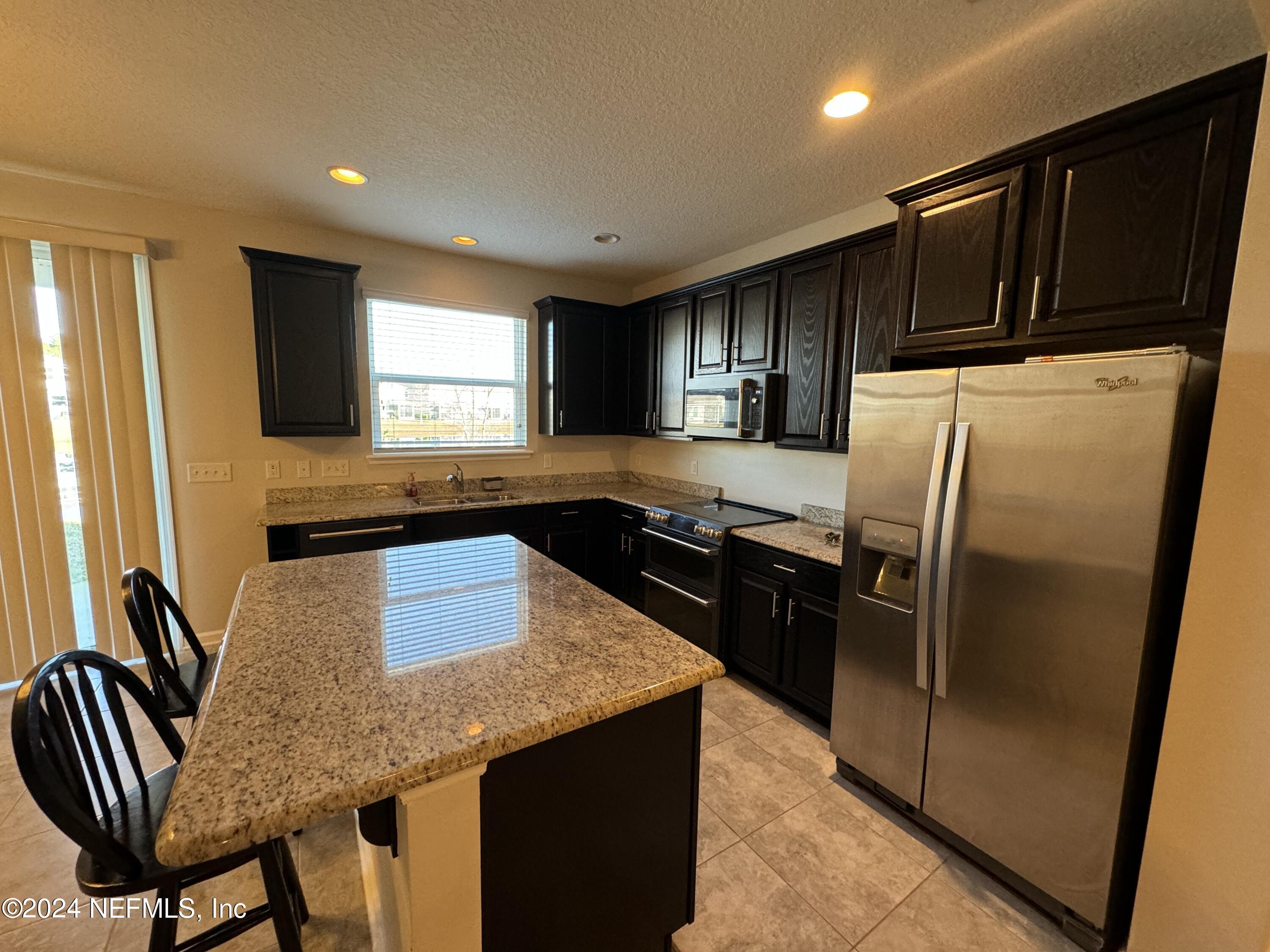 144 Nelson Lane St. Johns, FL 32259 - Photo 5 of 18 a kitchen with granite countertop a refrigerator and a stove top oven