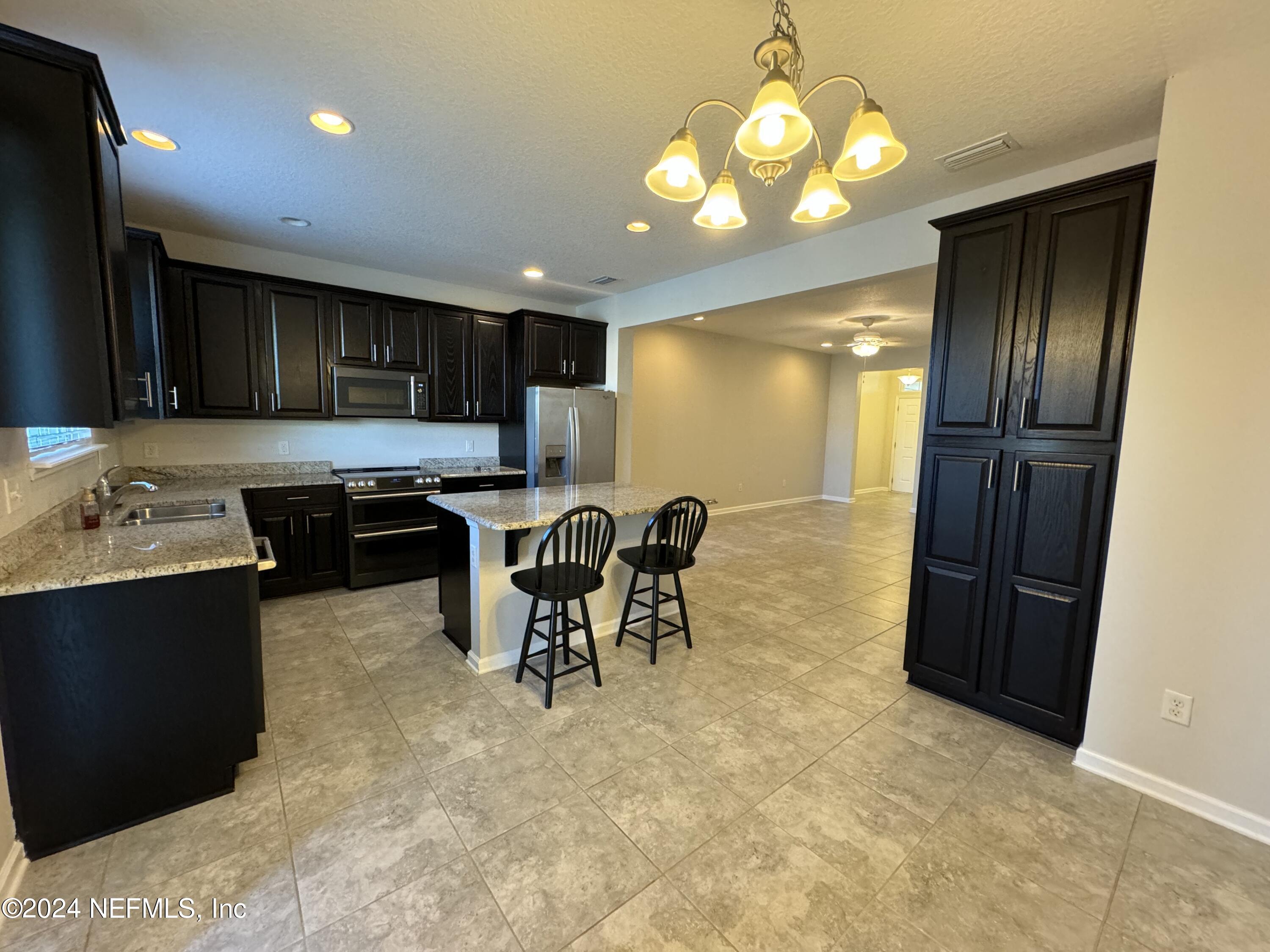 144 Nelson Lane St. Johns, FL 32259 - Photo 8 of 18 a kitchen with stainless steel appliances granite countertop a sink refrigerator and cabinets