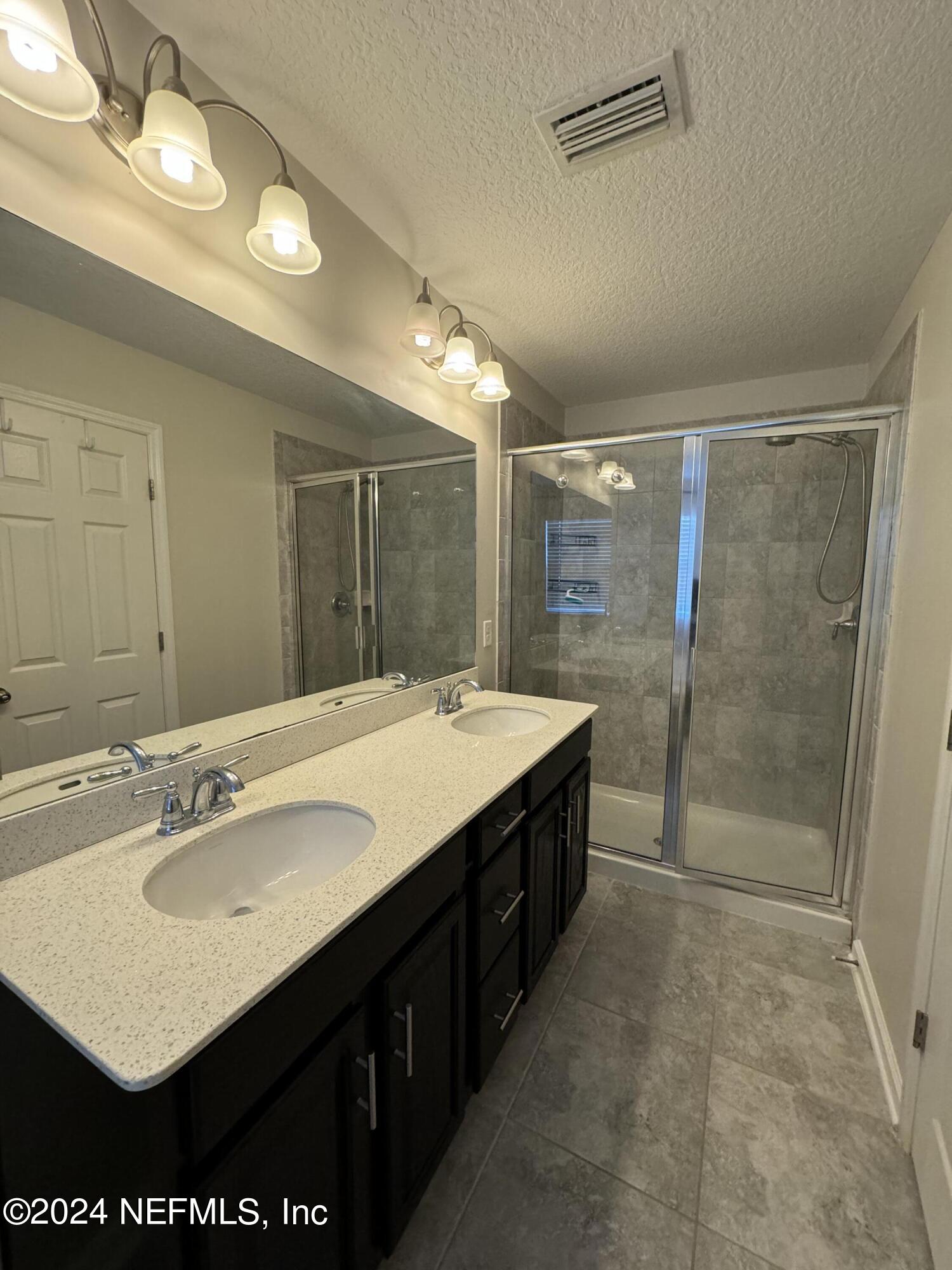 144 Nelson Lane St. Johns, FL 32259 - Photo 9 of 18 a bathroom with a sink vanity granite and shower