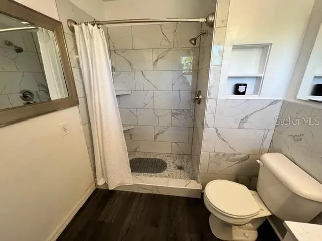 a white toilet sitting next to a bathroom sink and a shower