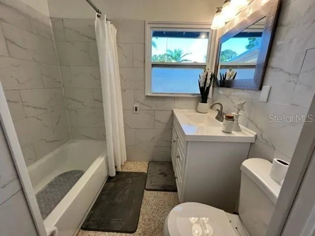 a bathroom with a sink toilet a mirror and shower