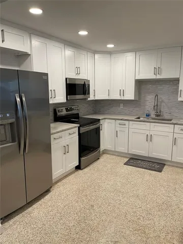 a kitchen with stainless steel appliances granite countertop a stove a sink and a refrigerator
