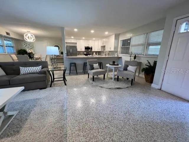 a living room with furniture and a view of kitchen