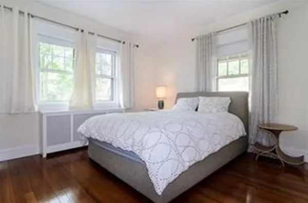 a large bed sitting in a bedroom next to a window