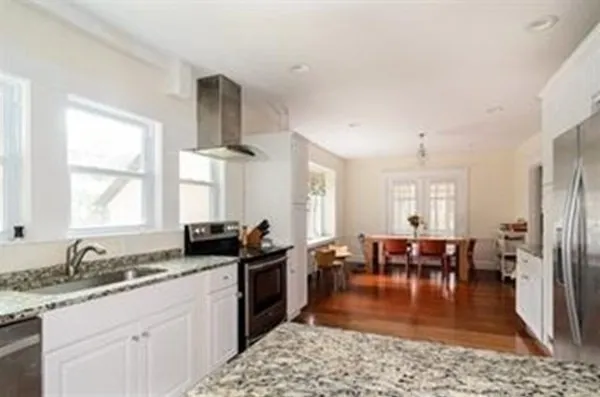 a kitchen with granite countertop a sink stove and dining table