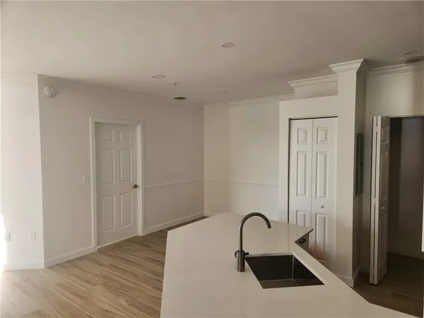 a view of a room with wooden floor and a floor to ceiling window