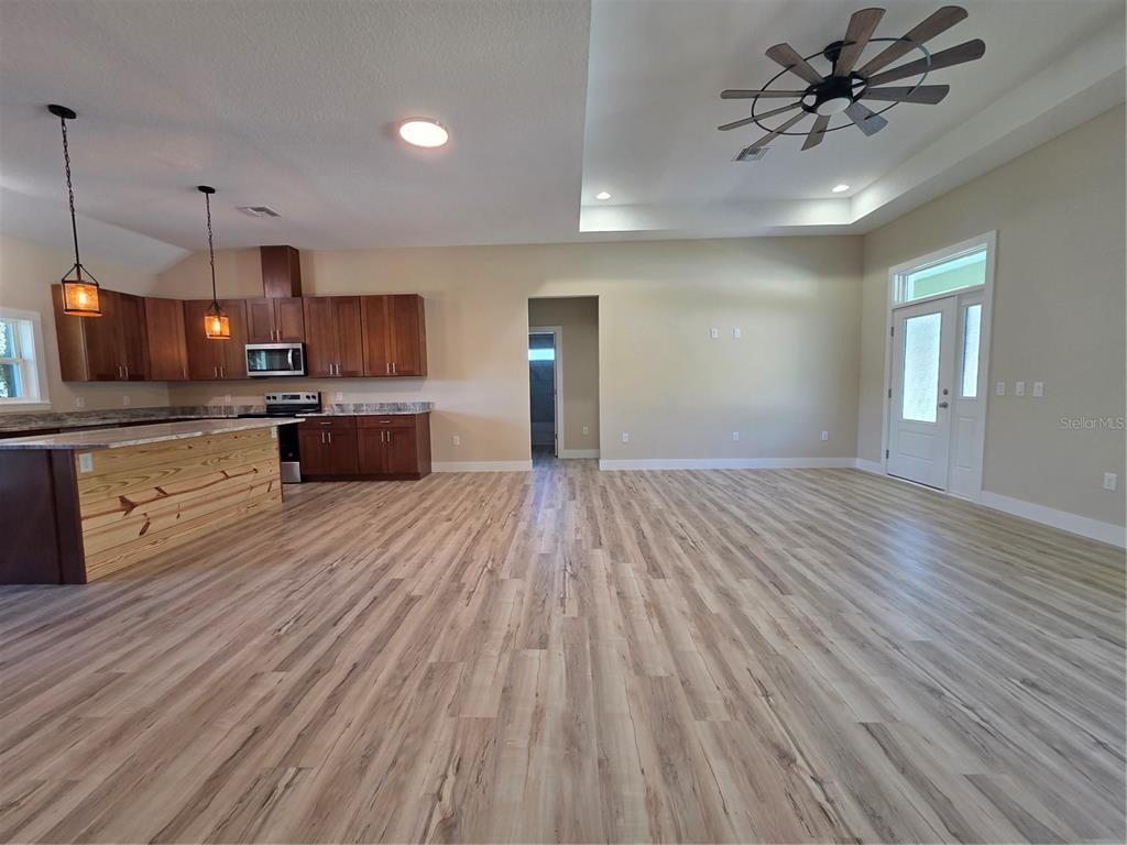 8005 North Terrel Point Citrus Springs, FL 34434 - Photo 14 of 41 a large kitchen with kitchen island a stove a sink dishwasher a refrigerator and white cabinets with wooden floor