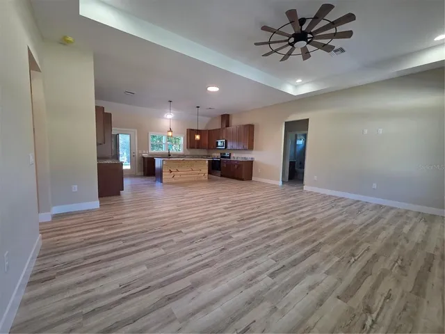 a view of a kitchen with a sink and dishwasher with wooden floor