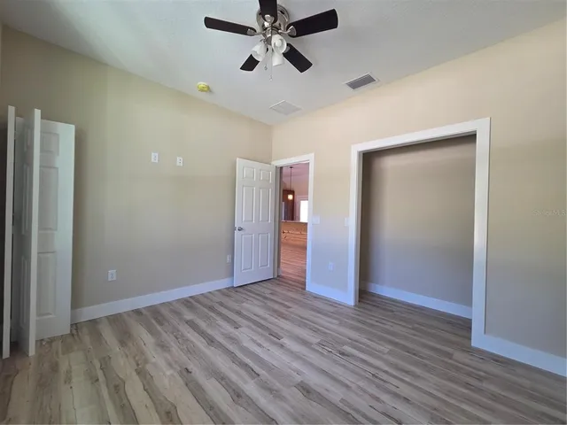 a view of a hallway with wooden floor and furniture
