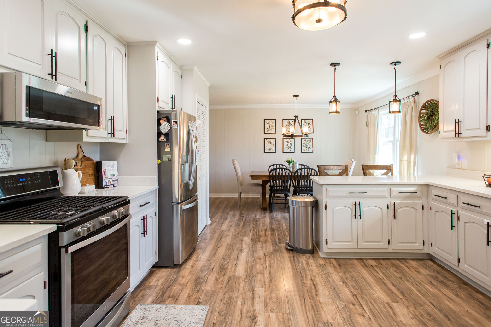 6737 Hacklebarney Road Blackshear, GA 31516 - Photo 13 of 40 a kitchen with stainless steel appliances a stove top oven a sink dishwasher a refrigerator with white cabinets and wooden floor