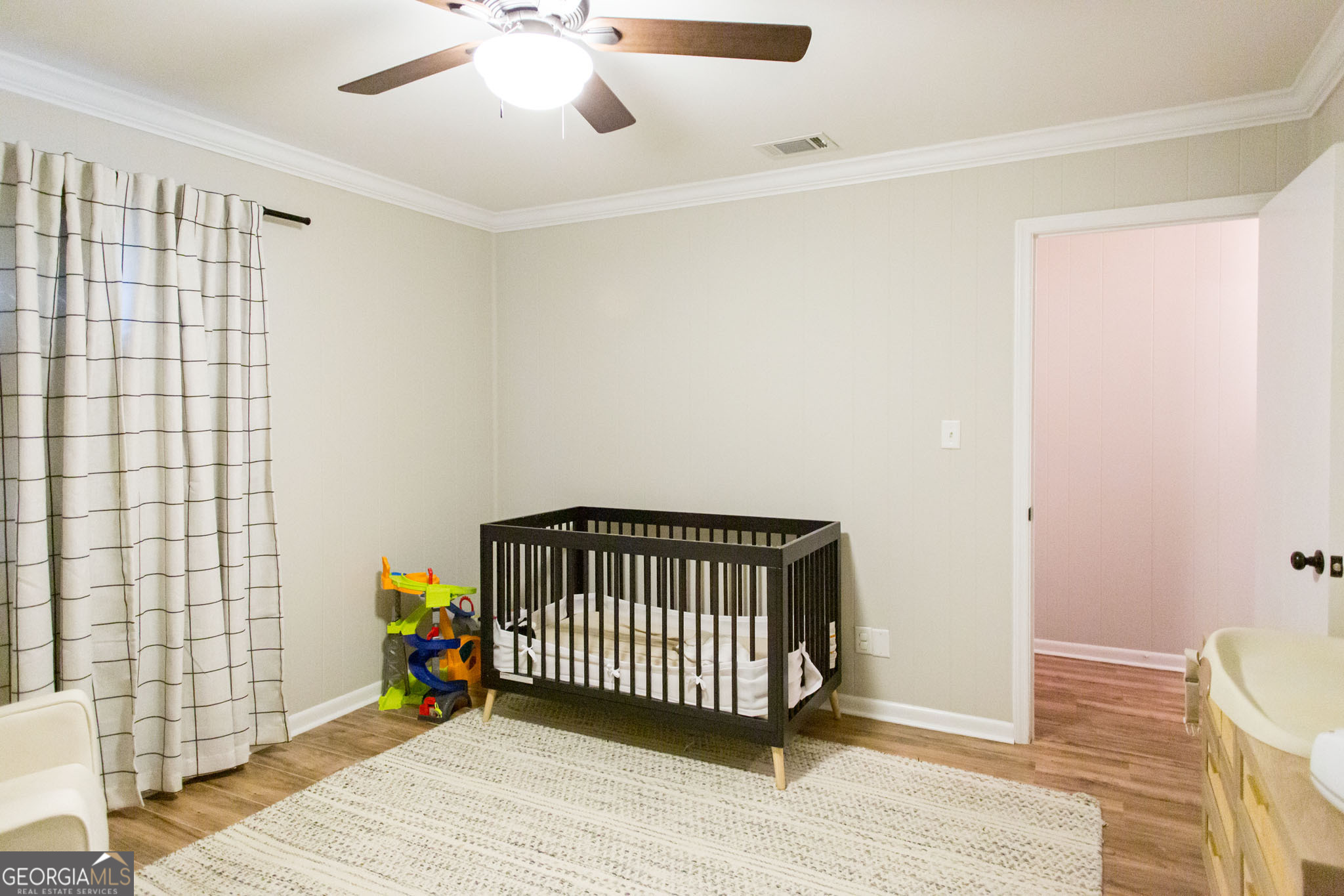 6737 Hacklebarney Road Blackshear, GA 31516 - Photo 29 of 40 a view of a livingroom with wooden floor and a ceiling fan