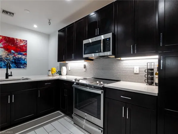 a metallic refrigerator freezer sitting in a kitchen