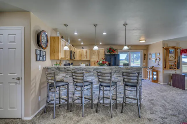 a kitchen with granite countertop a refrigerator and a stove top oven