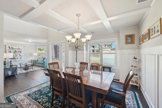 a view of a dining room with furniture a chandelier and wooden floor