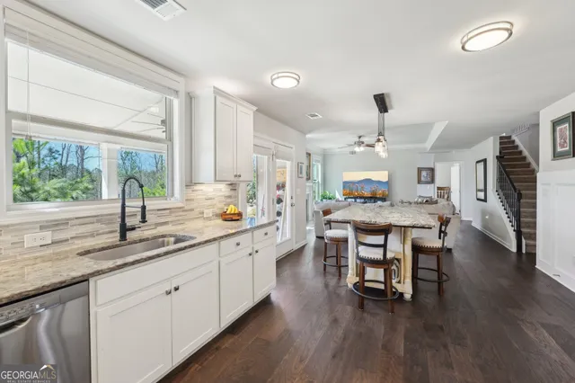 a kitchen with a table chairs sink and cabinets